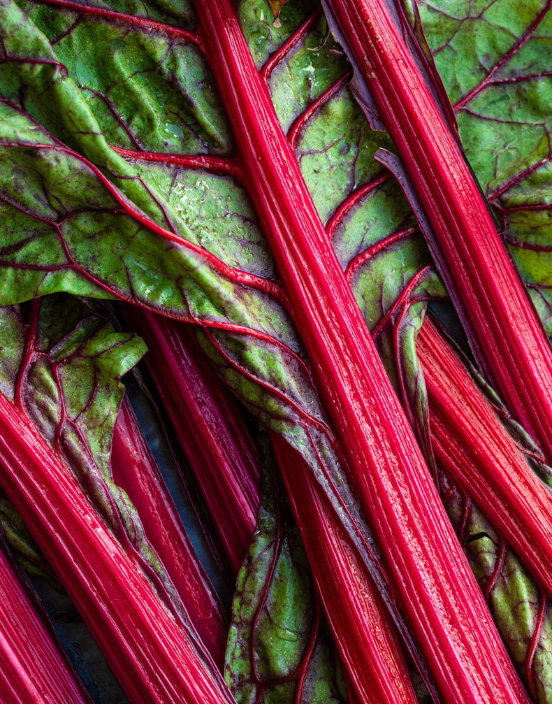 Rhubard is a curious vegetable. It has dark green leaves, but peek underneath, and you’ll see vibrant red stems. It’s these stems that we cook and eat in desserts such as rhubarb crumble.