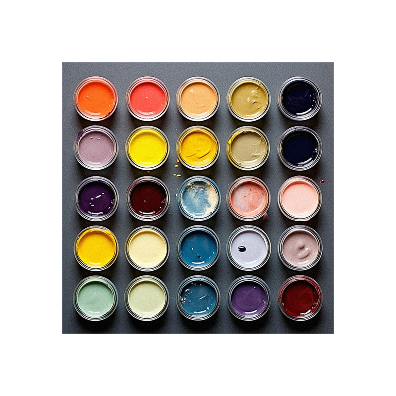 A collection of paints in different colors on a gray surface.