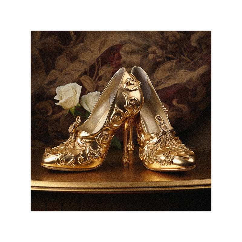 A pair of gold high heeled shoes on a table.