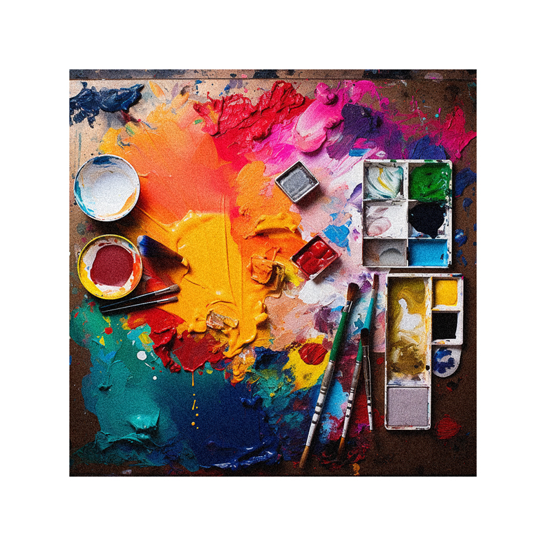 An artist's palette, paints and brushes on a table.